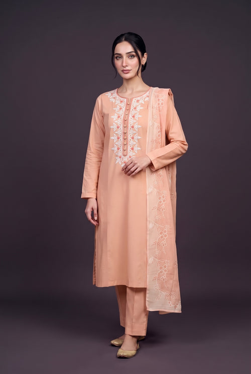 Model wearing the Apricot Blossom Suit in soft apricot, showing the white neckline embroidery and covered buttons