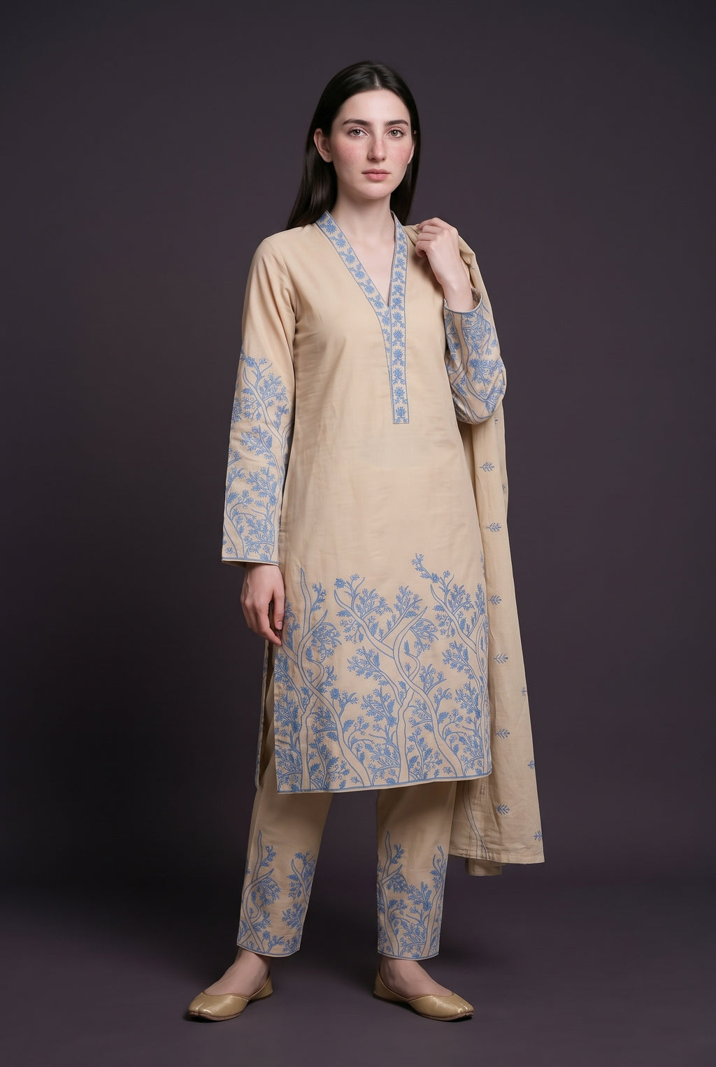 Model wearing the Grove Suit in sand, showing the embroidered V-neckline and embroidered sleeves