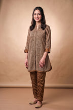 Model wearing the Bronze Herringbone Suit in brown herringbone print with bronze trousers, full-length front view