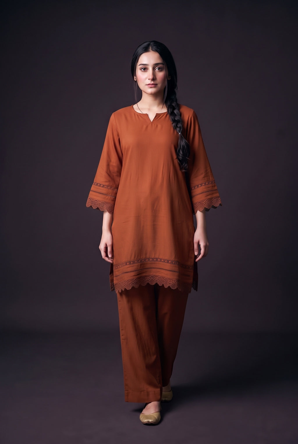 Model wearing the Lace Trim Suit in rust, showing the lace bell sleeves and lace hem