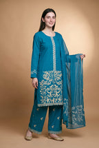 Model wearing the Blossom Tree Suit in peacock blue, full-length front view with the sheer dupatta