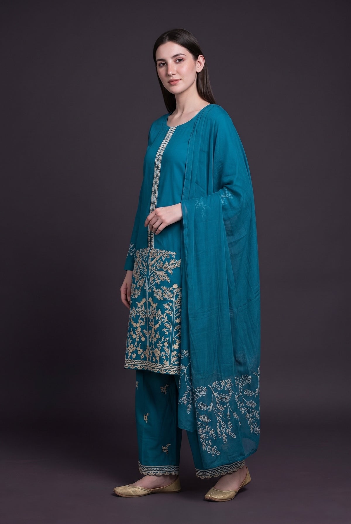 Model wearing the Blossom Tree Suit in peacock blue, showing the embroidered tree panel and trouser hem