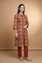Model wearing the Maroon Star Tile Suit in maroon and beige print with brick red trousers, full-length front view