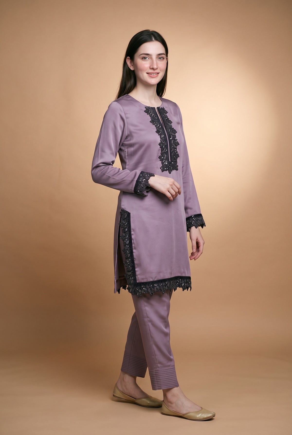 Model wearing the Mauve Noir Lace Suit in mauve, full-length view showing the lace-edged hem and pintucked trousers