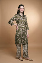 Model wearing the Olive Blossom Suit in olive floral print with zebra-stripe trousers, full-length front view