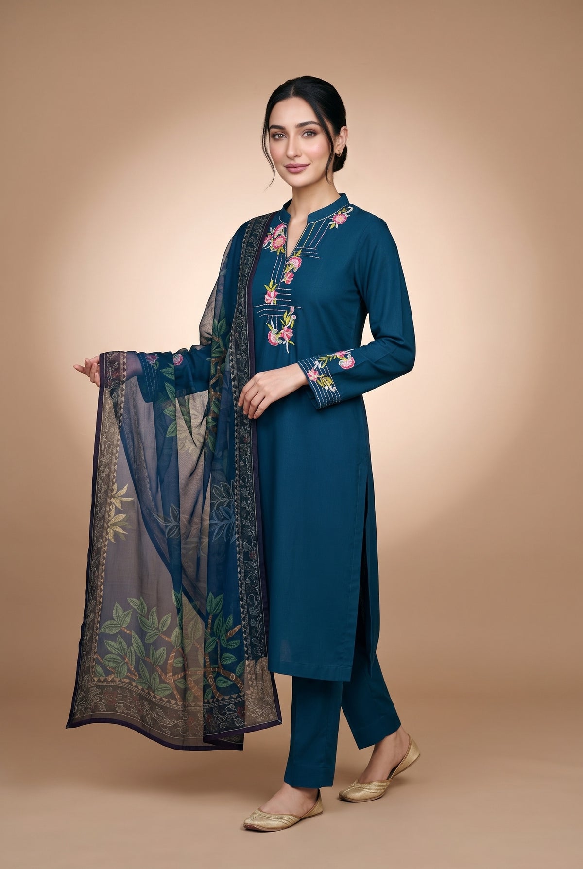 Model wearing the Peacock Carnation Suit in peacock blue, full-length front view holding the tree-print dupatta