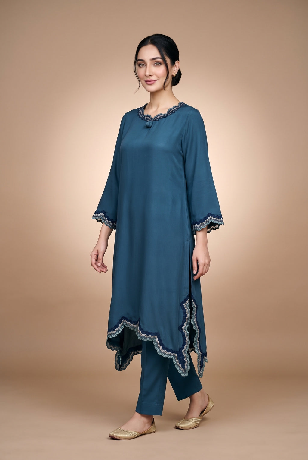 Model wearing the Petrol Scallop Suit in petrol blue, full-length view showing the scalloped handkerchief hem
