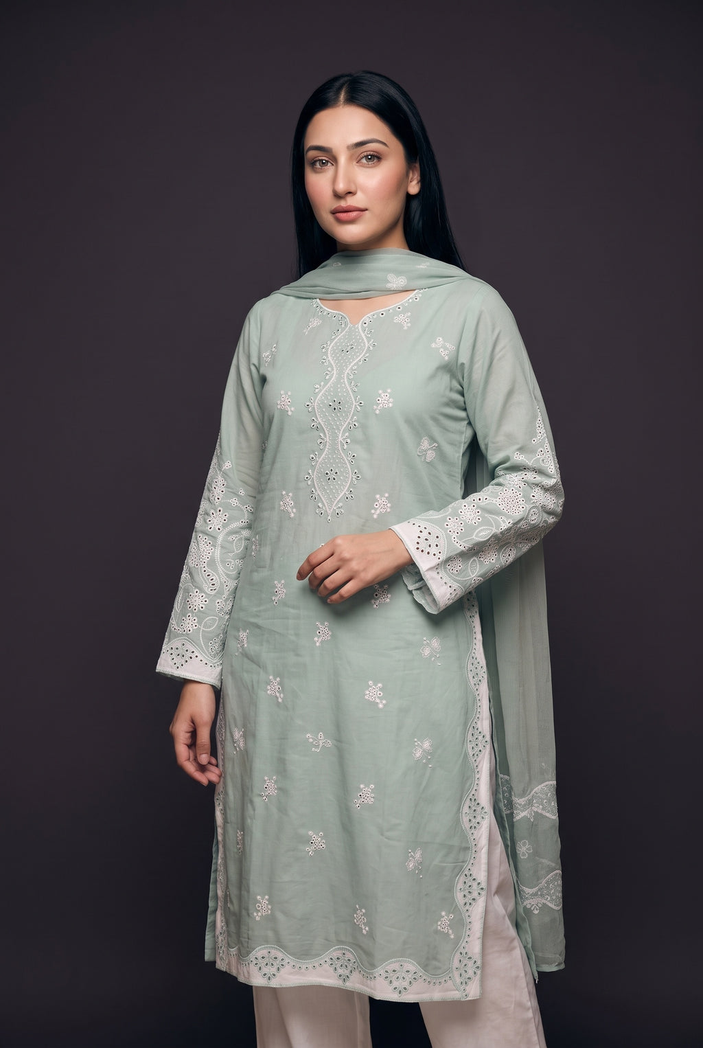 Model wearing the Sage Scallop Eyelet Suit, showing the embroidered centre panel and eyelet sleeves