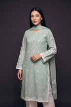 Model wearing the Sage Scallop Eyelet Suit, showing the embroidered centre panel and eyelet sleeves