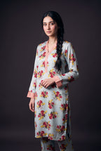 Model wearing the Sky Bouquet Suit, showing the striped pink V-neck band and cuffs